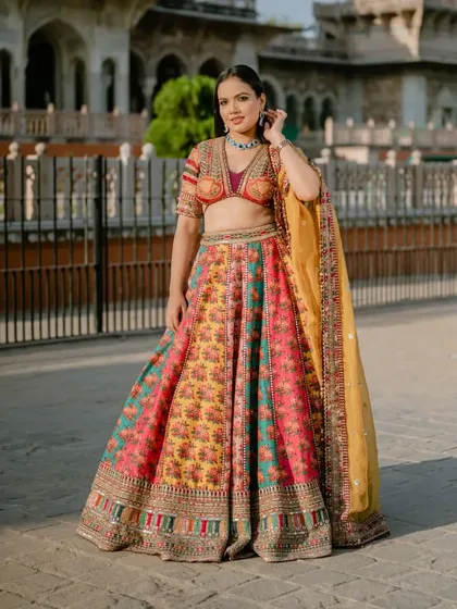 A stunning solo portrait of the bride in her vibrant, multi-colored lehenga. The grandeur of Albert Hall in the background perfectly complements her royal look.