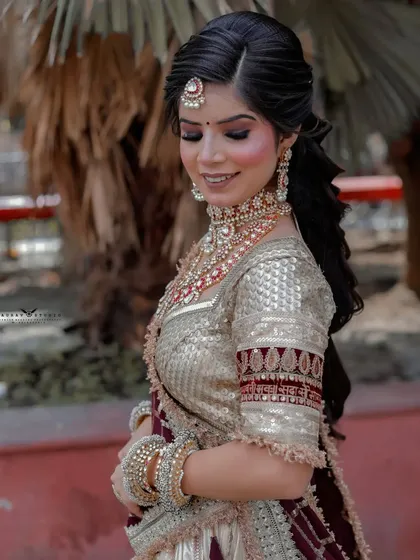 A serene portrait with the bride looking down, highlighting her makeup and the intricate blouse design.