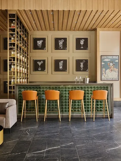 A wider view of the bar and lounge area, showcasing the combination of wood paneling, a distinctive bar design, and relaxed seating arrangements.