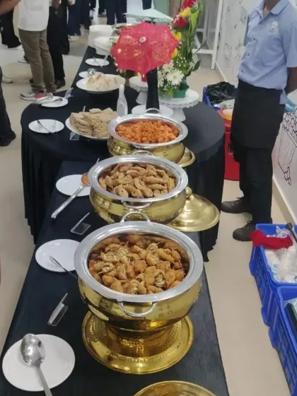 Guests enjoying our high-tea service at a corporate event. The buffet includes traditional Indian snacks served in our elegant golden chafing dishes.