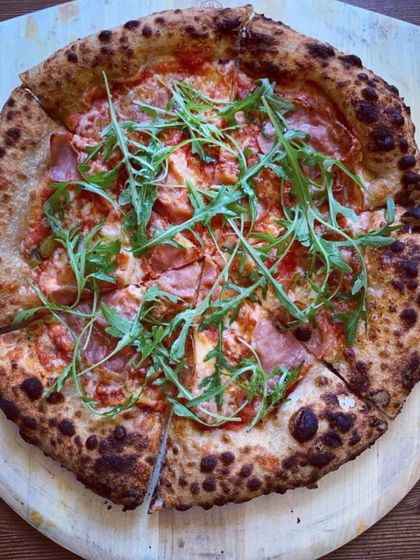 A delicious pizza topped with savory prosciutto and fresh, peppery arugula. The salty meat and fresh greens create a perfect balance of flavors on my classic Neapolitan crust.