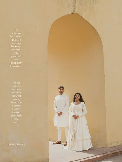 A classic portrait within a sandstone arch in Jaipur. The simplicity of the composition and the couple's coordinated white outfits create a serene and elegant pre-wedding photograph.