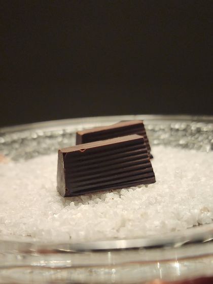My handmade lemon curd dark chocolate bonbons, presented simply on a bed of sugar. A perfect treat for a special occasion like Valentine's Day.