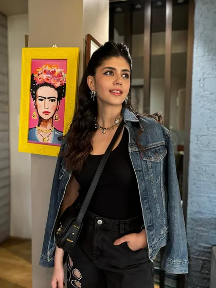 A candid shot of actress Sanjana Sanghi, showing off the half-up hairstyle with beachy waves. This is a great example of a relaxed yet stylish celebrity look.