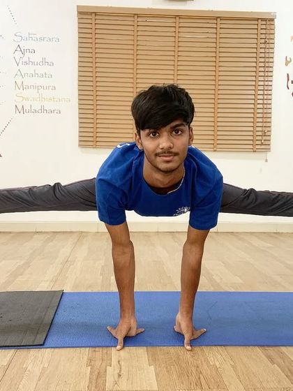 A young student uses stools to practice a full side split, showing that with the right tools and guidance, anything is possible.