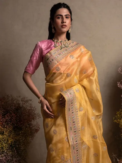 Beyond the main ceremony, we curate sarees for every function. This stunning yellow organza saree, with its delicate hand embroidery, is a light and graceful option perfect for a sangeet or reception.