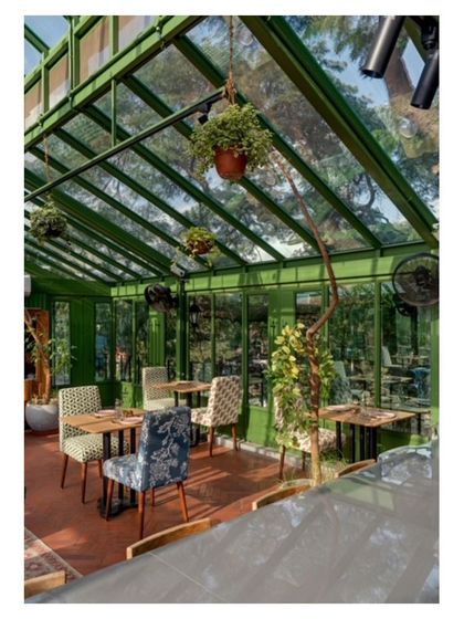 The glass ceiling and walls of the rooftop studio offer views of the surrounding tree canopy. We designed the layout with varied seating arrangements to accommodate everything from intimate dinners to larger design workshops.