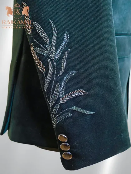 A view of the sleeve cuff of the green velvet Jodhpuri, highlighting the detailed embroidery and buttons.