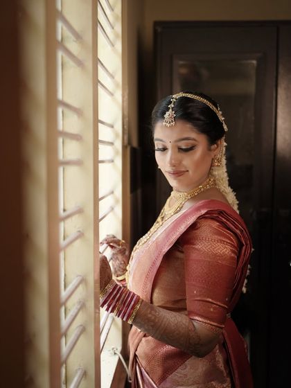 A quiet moment of reflection for the bride. I love capturing these candid shots where the makeup looks soft and beautiful in natural light, highlighting the intricate details of her look.
