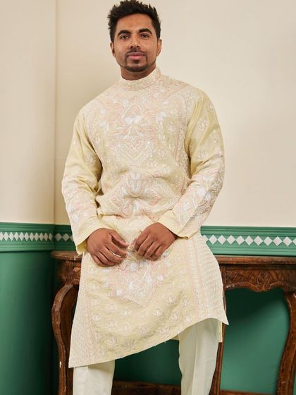 This shot shows the asymmetric cut and intricate embroidery of our canary yellow kurta, paired with off-white trousers.