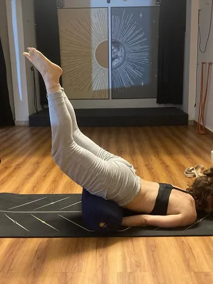 This is a variation of Shalabhasana (Locust Pose) using a bolster for support. The prop helps lift the chest, making it easier to engage the back muscles and build core strength.