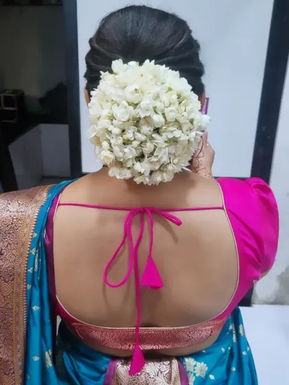A classic and elegant bridal hairstyle. This beautiful low bun is adorned with fresh white gajra, a timeless choice for any traditional wedding ceremony.
