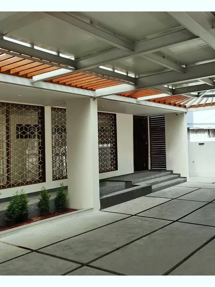 The entrance and parking area under the large steel canopy, showcasing the home's modern and geometric design language.