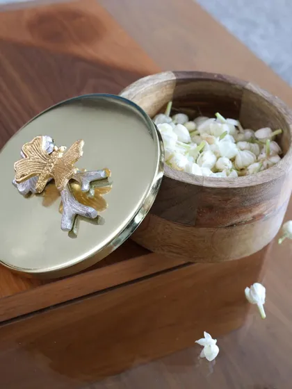 This version of our keepsake box features a wooden base and a polished gold lid with a dual-tone floral accent. The mix of materials adds a warm, organic touch to this elegant storage piece.