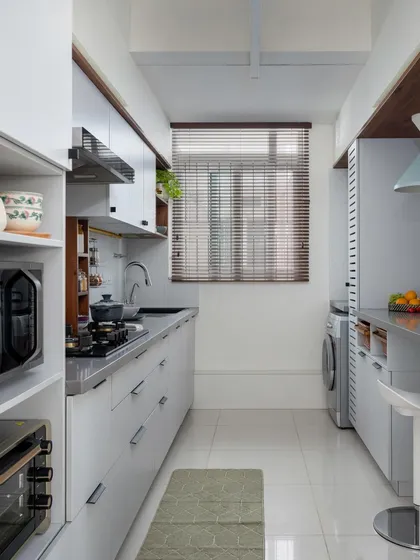 A full view of the galley kitchen from our 'Utopian Dreams' project, showcasing how we integrated a breakfast counter and laundry area without compromising on storage or workspace.