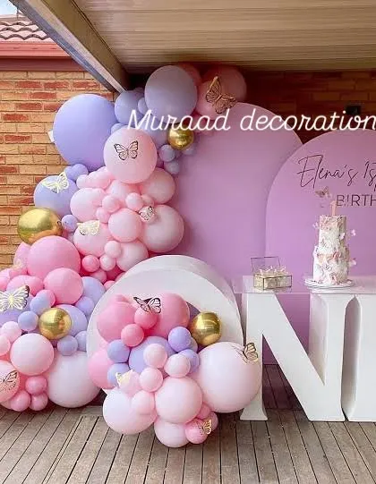 A beautiful butterfly theme for Elena's first birthday. We used a pastel palette of pink, purple, and gold balloons, large 'ONE' block letters, and butterfly decals to create this enchanting outdoor setup.