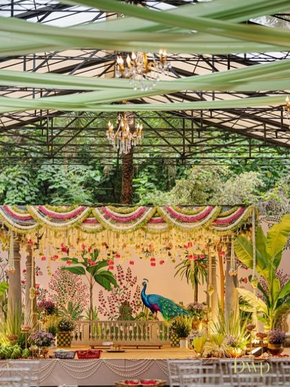 A detailed shot of the mandap stage, where the hand-painted peacock on the backdrop stands out. This custom artwork was the centerpiece of the decor, reflecting a theme of grace and beauty.