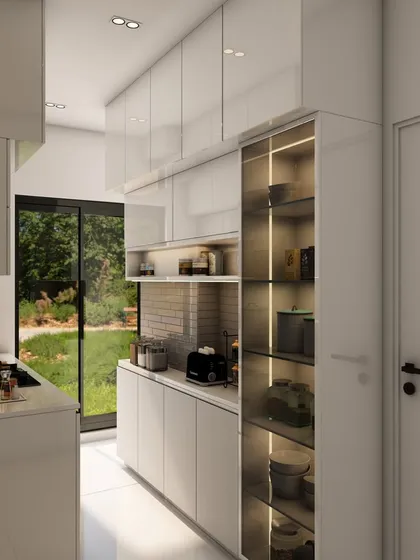 A view down the length of the minimalist white kitchen, emphasizing the seamless design and the bright, open feel.