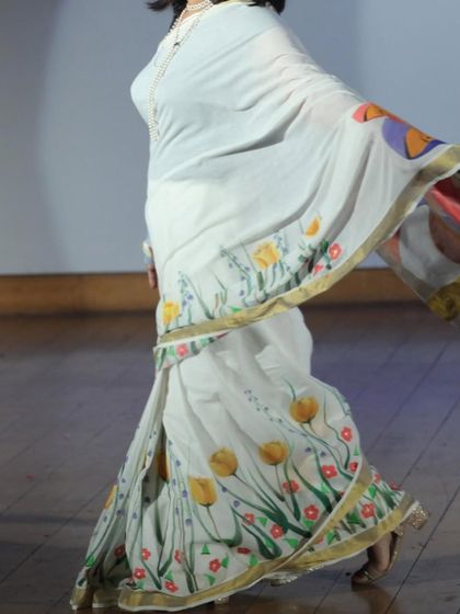 A hand-painted saree in motion. I love creating custom motifs for sarees, like these yellow tulips along the border, turning a traditional garment into a one-of-a-kind piece of wearable art.