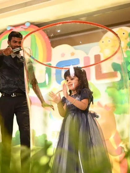 A young girl claps with delight from inside a giant bubble. Our performers are experts at interacting with children, ensuring they feel comfortable and have a fantastic time during the show.