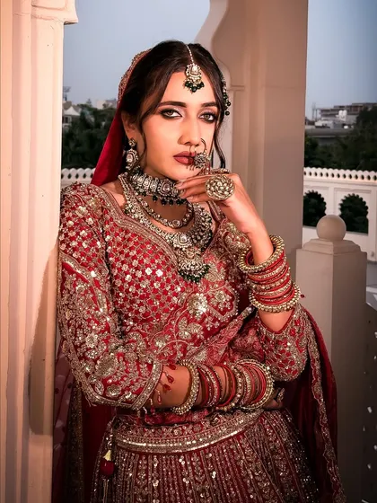 A legacy in red. This close-up captures the essence of a timeless Indian bride with bold, defined eyes, glowing skin, and intricate jewelry, creating a powerful and regal statement.