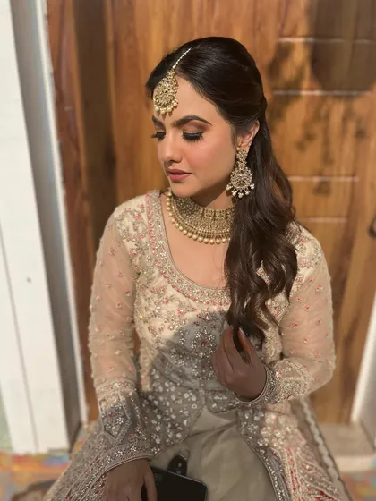 A side profile showing the soft curls and the beautiful glow on her skin. This is a versatile look for any wedding guest.