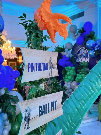 We love creating immersive game experiences. At this dinosaur-themed party, we set up custom wooden signs for activities like "Pin the Tail" and the ball pit, adding to the prehistoric jungle atmosphere.