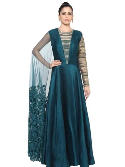 Make a grand entrance with this teal green gown by Ridhima Bhasin, featuring a dramatic embroidered cape. The combination of a sleek silhouette, embellished sleeves, and a deep V-neck creates a look that is both elegant and bold, perfect for a cocktail party or reception.