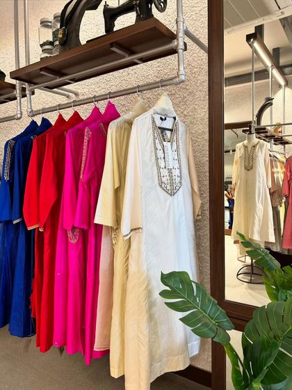 A rack of classic kurtas in vibrant hues of red, pink, and blue, showcasing the breadth of my curated collection.