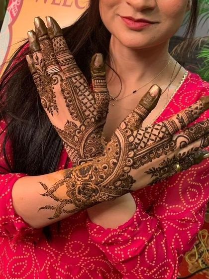A happy client showing off her gorgeous, full-coverage bridal mehendi.