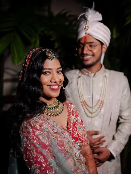 A happy couple at their reception. The bride's makeup is glamorous and modern, perfect for celebrating with family and friends.