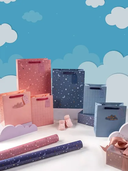 A whimsical and creative scene for Rae's children's gift wrap collection. The use of paper clouds and a sky-blue background creates a dreamy, imaginative world for the products.