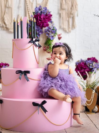 Sitting pretty on a giant, stylish cake prop. This is a great option for a beautiful birthday portrait before the actual cake smash begins.
