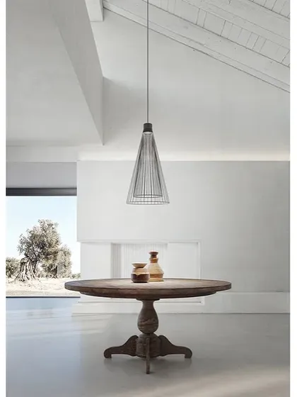 The Ikonika collection also includes this suspension lamp, seen here in a minimalist indoor dining space. Its wireframe structure is light and airy, allowing it to define a space without overwhelming it.