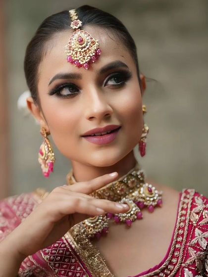 A close-up profile shot, showing the clean lines of the makeup and the beautiful jewelry.