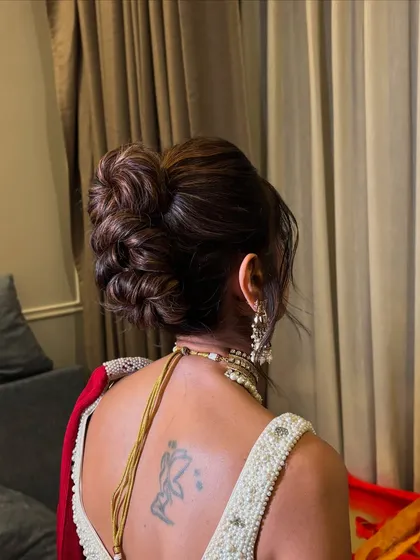 This image captures the volume and height of the stylish messy updo.