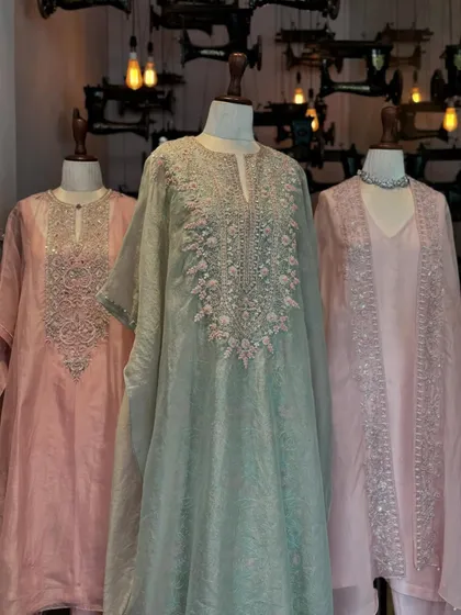 Pastel perfection. This display features kaftans and suits in soft shades of mint green and pink, all adorned with intricate silver and pink embroidery.