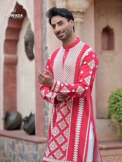 A close-up of the vibrant red kurta, focusing on the detailed white embroidery. The cheerful color and fine craftsmanship make it a standout piece for any celebration.