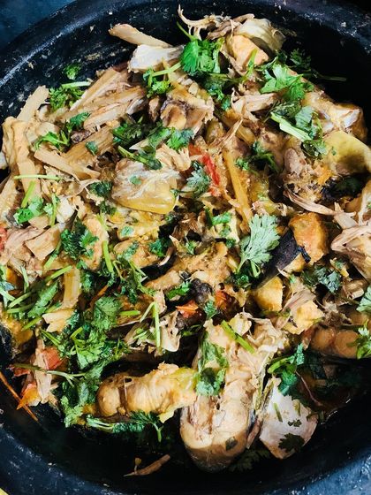 A beautiful dish of fish cooked with bamboo shoot, banana flower, and banana stem, garnished with fresh coriander.