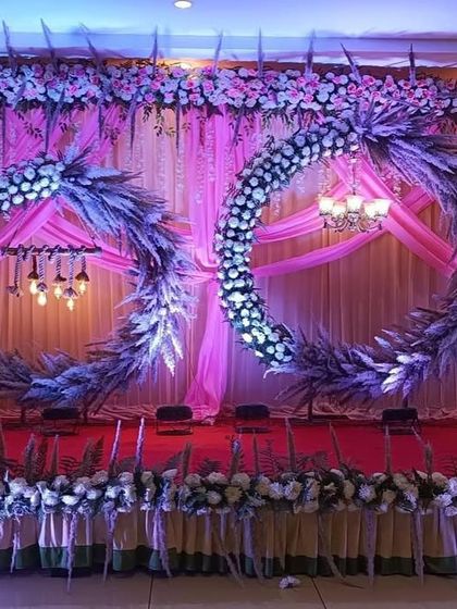 For a unique stage design, we created these large rings decorated with flowers and feathers. This kind of creative decor ensures your wedding stage stands out and looks fantastic in photos.