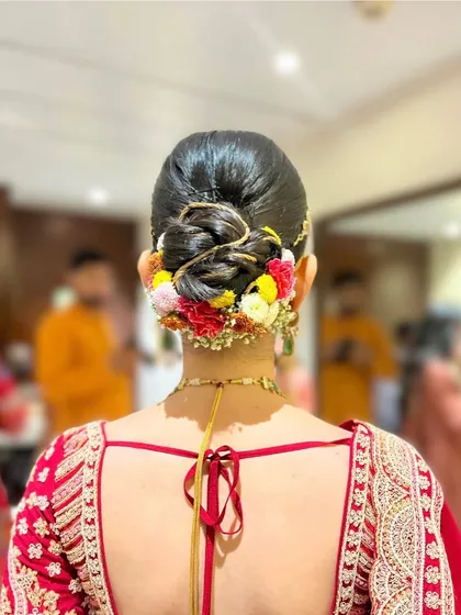 A colorful and vibrant floral bun, perfect for a daytime wedding or Haldi ceremony. The mix of flowers adds a playful and festive touch.