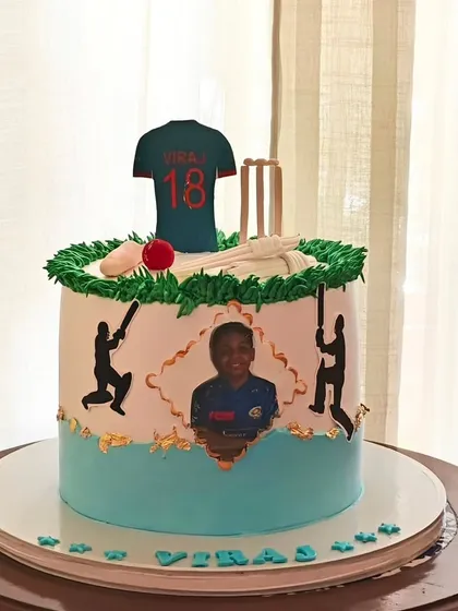 A personalized cricket cake featuring an edible photo of the birthday boy, along with his favorite player's jersey number and cricket-themed decorations.