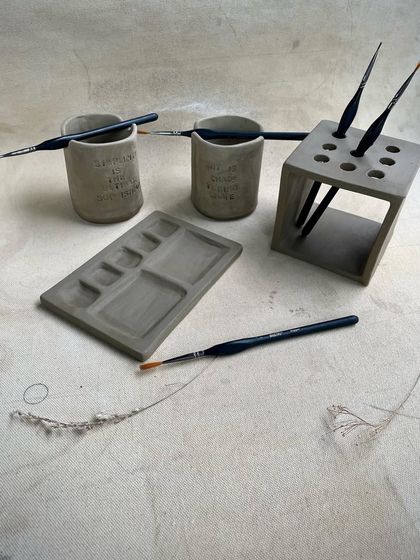 A duplicate of image 17, showing the unfired paint palettes and brush holders. These functional pieces are a popular project in our hand-building classes.