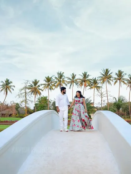 A romantic shot of the couple walking hand-in-hand across a beautiful bridge, perfect for telling their love story.