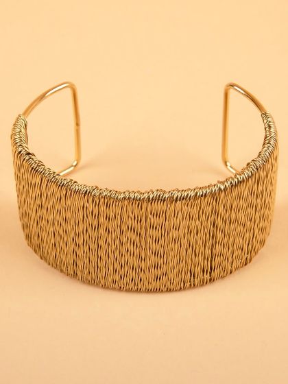 A back view of the woven gold cuff bracelet.
