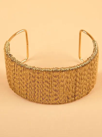 A back view of the woven gold cuff bracelet.