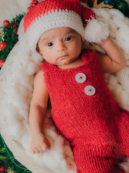 Santa's little helper, all ready for Christmas. This 2-month-old looks so adorable in his festive red outfit and Santa hat.
