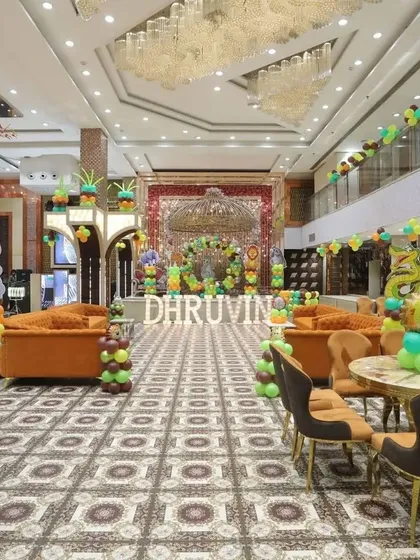 A wide shot of a large party hall decorated for a jungle-themed birthday, showing the scale of the event.