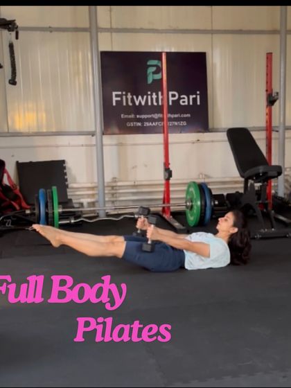 A snapshot from a full-body Pilates session. The boat pose hold with a dumbbell challenges the deep abdominal muscles, hip flexors, and back extensors.