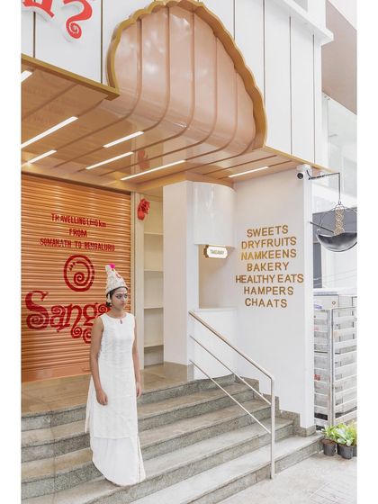 The multi-foliate arched entrance at Sangam Sweets, with a shutter fascia that gives a brief of the brand's journey from Somnath to Bengaluru.